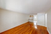 Located at 135 Chestnut St in Foxborough, MA, this single-floor, 2-bedroom, 1-bathroom unit offers a practical and comfortable layout. The living room is a standout space, featuring rich hardwood floors that run throughout and a distinctive white painted brick accent wall that adds texture and character. The open sightline from the living area into the kitchen creates a connected, spacious feel. A large window with vertical blinds allows generous natural light and outdoor views.

The kitchen is well-equipped with warm oak cabinetry extending to the ceiling, a tile backsplash, a gas range, dishwasher, and a separate refrigerator. Light ceramic tile flooring and windows with outdoor views make the kitchen bright and functional. A door in the kitchen provides direct exterior access.

The two bedrooms continue the hardwood flooring theme, with the primary bedroom offering a large window overlooking the outdoors. The second bedroom is a comfortable, well-proportioned space with clean, neutral walls. Five closets throughout the unit provide exceptional storage.

The bathroom features classic white subway tile surrounding a full tub/shower, complemented by light neutral walls and tile flooring. A hallway connects the rooms efficiently, rounding out this well-organized, move-in ready unit.
