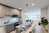 Located in the heart of Calgary's downtown at 736 8 Ave SW, this well-appointed 2-bedroom, 2-bathroom unit offers a thoughtfully designed single-floor layout that maximizes both function and style. The open-concept kitchen and living area serves as the centerpiece of the space, featuring a modern kitchen with two-tone cabinetry — warm wood uppers paired with sleek grey lowers — complemented by a white subway tile backsplash, quartz countertops, stainless steel appliances, and a central island with seating. The kitchen flows seamlessly into a bright living area bathed in natural light through large floor-to-ceiling windows that frame urban downtown views. Both bathrooms are finished with marble-look tile, soaker tubs, and matte black fixtures for a clean, contemporary aesthetic. The primary bedroom offers a comfortable footprint with mirrored closet doors, while the second bedroom provides flexibility for guests or a home office. A separate den adds further versatility to the layout. Additional highlights include light hardwood-style flooring throughout, multiple closets for generous storage, in-unit laundry, and double doors with a transom window in the entry area. The overall ambiance is clean, modern, and well-suited for downtown Calgary living.