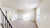 Located at 65 Carriage Station Dr in Cincinnati, Ohio, this two-bedroom, two-bathroom two-story home offers a practical and comfortable layout spread across two floors. The main level features a welcoming entrance that opens to a bright living room with plush carpeting and natural light streaming through blinds-fitted windows. The kitchen is efficiently designed in an L-shaped configuration, featuring warm wood-toned cabinetry, granite-look countertops, wood-style vinyl flooring, and a full suite of white appliances including a dishwasher, electric range, microwave, and refrigerator. Both bathrooms are clean and functional — one features a full tub-shower combo with a curved curtain rod, while the other includes a vanity with a granite-look countertop and a lighted mirror. Upstairs, the two carpeted bedrooms offer a serene retreat, each filled with natural light from windows with blinds. The generously sized primary bedroom includes a sliding-door closet. Additional highlights include four closets throughout, a dedicated laundry area, a utility room, and a hallway connecting the upper level. The textured ceilings and neutral color palette create a clean, move-in-ready ambiance throughout.