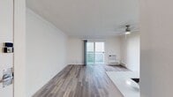 This contemporary 550 square foot apartment in Newport Beach offers a thoughtfully designed living space. The open-plan layout maximizes the use of space, featuring a living room that seamlessly integrates with the kitchen area. The kitchen boasts modern appliances, including a stainless steel refrigerator and oven, with a convenient breakfast bar for casual dining.

Hardwood floors run throughout the apartment, adding warmth and elegance to the space. Large sliding glass doors flood the living area with natural light and provide access to one of the two balconies, offering views of the surrounding area and allowing for indoor-outdoor living.

The bathroom features a clean, modern design with a white vanity, large mirror, and contemporary fixtures. The apartment's neutral color palette creates a bright, airy atmosphere that can easily be personalized.

A notable feature is the presence of two balconies, unusual for an apartment of this size, providing additional outdoor space for relaxation or entertainment. The exterior of the building showcases well-maintained landscaping with colorful flowers, adding to the overall appeal of the property.

This apartment combines functionality with style, making efficient use of its 550 square feet to create a comfortable living environment in the desirable Newport Beach area.