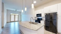 Located at 1500 German School Rd in Richmond, VA, this well-appointed two-bedroom, two-bathroom unit offers a thoughtfully designed single-floor layout with modern finishes throughout. The kitchen serves as a central highlight, featuring crisp white cabinetry extending to the ceiling, granite countertops, black stainless appliances, and a peninsula island with an undermount sink illuminated by pendant lighting — all set over wood-look tile flooring that flows through the main living areas.

Both bedrooms are carpeted and offer a calm, neutral palette with natural light provided by windows fitted with blinds. The generously sized primary bedroom includes its own dedicated closet with wire shelving systems, while a second walk-in closet provides extensive multi-tier wire shelving for exceptional storage capacity.

The two bathrooms maintain a consistent, clean aesthetic. One features a granite-topped vanity, wood-look tile flooring, and a tub/shower combo, while the second offers a tub/shower combination with a framed glass sliding door. Both bathrooms are finished with brushed nickel hardware and towel bars.

Overall, the unit presents a clean, contemporary feel with a neutral color scheme, practical storage solutions, and functional design details suited for comfortable everyday living in Richmond.