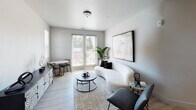 This contemporary apartment at 1200 Allison Dr. in Vacaville, California offers a well-designed single-floor layout with a clean, modern aesthetic throughout. The living area is bright and inviting, featuring light wood-style flooring, neutral-toned walls, and direct access to an outdoor balcony through full-length glass doors that flood the space with natural light. A compact dining nook complements the living area seamlessly.

The kitchen is outfitted with sleek white cabinetry extending to the ceiling, stainless steel appliances including a gas range, refrigerator, and dishwasher, and a central island with a white quartz countertop — ideal for both meal preparation and casual dining.

Multiple bedrooms provide comfortable retreats, each featuring light flooring, neutral walls, and windows that frame outdoor views of the surrounding neighborhood. The rooms offer ample space and a calm, restful ambiance.

The bathrooms are finished to a high standard. The primary bathroom includes a dual-sink vanity with a large mirror, a soaking tub, and built-in shelving, while the secondary bathroom features a shower-tub combination. Both spaces maintain the home's consistent modern, light palette, creating a cohesive and polished living environment throughout.