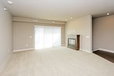 This single-floor residence offers a thoughtfully designed layout with a clean, contemporary aesthetic throughout. The open-concept living area is anchored by a sleek fireplace with a wood-framed surround and is finished with plush wall-to-wall carpeting and neutral walls that create a warm, inviting atmosphere. A sliding glass door allows natural light to fill the space and provides access to the outdoors.

The galley-style kitchen is efficiently arranged with dark wood cabinetry, white quartz countertops, stainless steel appliances including a range and microwave, and wood-look flooring. A stainless steel sink sits opposite the cooking area, making the space both functional and visually cohesive.

The bedrooms are generously sized, each featuring soft carpeting, ceiling fans, and windows fitted with blinds that allow for natural light control. The primary bedroom includes direct access to an en-suite bathroom, while a spacious walk-in closet with wire shelving provides ample storage.

The bathrooms are finished with dark espresso cabinetry, white quartz countertops, and wood-look tile flooring. The primary bath includes a dual-sink vanity with a large mirror and a tub-shower combination. A second full bathroom mirrors this refined style with a well-lit vanity and clean fixtures throughout.