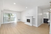 Located at 1515 2nd Street in the desirable coastal community of Coronado, California, this thoughtfully designed one-bedroom, two-bathroom residence offers a clean, modern aesthetic throughout its efficiently utilized single-floor layout. Light hardwood flooring runs seamlessly across the entire space, creating a warm and cohesive feel from room to room.

The open-concept living room is a standout, featuring recessed lighting, a classic white fireplace with built-in shelving, and floor-to-ceiling sliding glass doors that invite natural light and provide views of lush outdoor greenery. A gold-accented chandelier adds an elegant touch to the dining area nearby.

The galley-style kitchen is well-appointed with two-tone cabinetry — white uppers and dark lowers with gold hardware — paired with crisp white countertops and stainless steel appliances, including a range, microwave, and refrigerator.

The bedroom is a serene retreat with a large window, louvered bi-fold closet doors offering ample storage, and a dedicated closet area with open shelving. The primary bathroom features a sleek, modern vanity with a wide white quartz countertop, dark cabinetry, gold-framed mirror, and direct access to the bedroom. A second full bathroom includes a clean, white tub-shower combination.