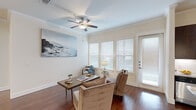This thoughtfully designed single-floor residence offers a cohesive blend of comfort and modern style throughout its well-defined living spaces. Rich hardwood flooring flows seamlessly through the main living, dining, and kitchen areas, complemented by crisp white walls and elegant crown molding that lend a polished character to the interior.

The dining area is an inviting focal point, anchored by a stylish chandelier and an octagonal mirror that adds visual depth to the space. The kitchen features dark espresso cabinetry, granite countertops, stainless steel appliances, and pendant lighting, creating a functional yet refined cooking environment. A hallway connects the main living areas to the private quarters with ease.

The living and flex spaces are brightened by multiple windows dressed with white blinds, allowing generous natural light to fill the rooms. Ceiling fans provide added comfort throughout. A versatile sitting or study area opens to an exterior door, offering convenient access to the outdoors.

The primary bedroom is a serene retreat with plush carpeting, while its en-suite bathroom impresses with dual undermount sinks set in granite countertops, dark wood cabinetry, tile-surround shower, and hardwood flooring. A walk-in closet with built-in shelving provides ample storage. The overall ambiance is warm, refined, and move-in ready.