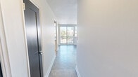 Located at 350 The East Mall in Toronto's Etobicoke neighbourhood, this well-appointed one-bedroom, one-bathroom unit offers a comfortable and functional layout across a generous single floor. Distinctive parquet wood flooring runs throughout the living areas and bedroom, adding warmth and character to the bright, neutral interior.

The open kitchen and living room area is thoughtfully designed, featuring white shaker-style cabinetry, a herringbone-patterned tile backsplash, stainless steel appliances including a refrigerator, electric range, and built-in microwave, as well as a dark-topped island/breakfast bar that provides additional prep and seating space. Light tile flooring in the kitchen complements the clean, modern aesthetic.

The living room is airy and sun-filled, with large sliding glass doors that open to a balcony, framing views of the surrounding Toronto skyline and greenery. Baseboard heating runs along the perimeter, ensuring year-round comfort.

The spacious primary bedroom features a large window with city views, parquet flooring, and ample wall space. The bathroom is finished with clean white subway tile in the tub-shower surround, light tile flooring, and crisp white fixtures, creating a bright and functional space. The unit's neutral palette and abundant natural light throughout make it a versatile and inviting home.