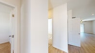 Located at 8250 Cliffdale Rd in Fayetteville, NC, this single-floor home offers a clean, modern interior designed for comfortable everyday living. The kitchen is a standout feature, outfitted with crisp white shaker-style cabinetry, light quartz countertops, a peninsula island, and stainless steel appliances including a refrigerator, range, microwave, and dishwasher. Light wood-style flooring flows throughout the main living and kitchen areas, lending warmth and continuity to the open layout. The living room is bright and airy, with natural light streaming through window blinds and a ceiling fan overhead. Bedrooms feature plush carpeting, ceiling fans, windows with blinds, and individual closets, including at least one with a reach-in configuration. The bathroom includes a full-size soaking tub with a tiled surround and built-in shelving niches. A dedicated laundry area with wire shelving, washer/dryer hookups, and a dryer vent connection adds practical utility. The home also includes an attached garage with a concrete driveway, set within a residential neighborhood surrounded by mature trees and neighboring homes.