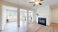 Located at 2146 Miller Chapel Rd SE in Conyers, Georgia, this two-story home offers a thoughtfully designed layout across two floors. The main level welcomes you through a graceful arched hallway that leads into a bright, open-concept living room and kitchen area. The living room features warm hardwood-style flooring, a ceiling fan, decorative columns, and a sleek fireplace as a focal point. The kitchen is outfitted with white shaker cabinets, granite countertops, stainless steel appliances, a tile backsplash, and a central island, all bathed in natural light from a large window. An attached garage with an automatic opener provides convenient access. The upper floor, the larger of the two levels, houses all three bedrooms, including a generously sized primary bedroom with a walk-in closet and an en-suite bathroom featuring a soaking tub, granite vanity, and wood-style flooring. Additional bedrooms include built-in closets. A dedicated laundry room with full-size washer and dryer hookups, multiple hallways, and a stylish open staircase with black metal balusters complete the upper level. With four full bathrooms and a clean, modern aesthetic throughout, this home offers functional living in a well-organized floor plan.