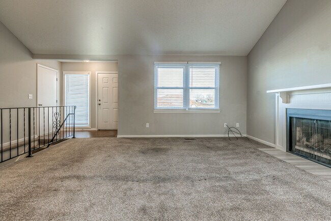 Sala de estar con techos abovedados, mucha luz natural y chimenea. - 13749 W 62nd St
