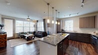 Located at 201 E Eldorado Pkwy in Little Elm, TX, this single-story residence offers a thoughtfully designed open-concept layout that seamlessly connects the kitchen and living areas. The kitchen is a standout feature, showcasing granite countertops, a large center island with bar seating, stainless steel appliances including a refrigerator, range, and built-in microwave, as well as two-tone cabinetry with dark lower and light upper cabinets. A glass tile backsplash and pendant lighting above the island add contemporary flair, complemented by track lighting overhead.

The living area is bright and welcoming, featuring large windows with horizontal blinds and curtains that invite abundant natural light. A ceiling fan adds comfort, and wood-style flooring flows throughout the entire unit, creating a cohesive aesthetic.

The bedrooms are comfortably sized, each with ceiling fans, natural light from well-placed windows, and views of the surrounding area. The bathroom includes a full soaking tub with tile surround. A dedicated hallway connects the private rooms, and an in-unit laundry room with a full-size washer and dryer provides added convenience. This well-appointed residence combines modern design with practical living features.