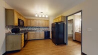 Located at 1927 Miller St in La Crosse, Wisconsin, this single-floor unit offers a practical and well-appointed layout designed for comfortable everyday living. Hardwood-style flooring flows throughout the main living areas, creating a cohesive and easy-to-maintain aesthetic.

The kitchen is a functional centerpiece of the space, featuring warm honey-toned wood cabinetry extending to the upper walls, dark granite-style countertops, and a mosaic tile backsplash that adds visual texture. Black appliances, including a refrigerator, range, microwave, and dishwasher, are included. Track lighting overhead illuminates the workspace efficiently. The kitchen opens directly to a spacious living area, promoting an airy, connected feel. The living room benefits from a sliding glass door that invites natural light and provides outdoor views, complemented by a ceiling fan for added comfort.

The bedroom features plush carpeting underfoot, a window with blinds, and a baseboard heater. A dedicated closet with built-in shelving provides organized storage. The bathroom includes a soaking tub, tile surround with decorative accents, a vanity with a granite-style countertop, and overhead cabinetry. A separate entry hallway with additional closet space completes the layout.