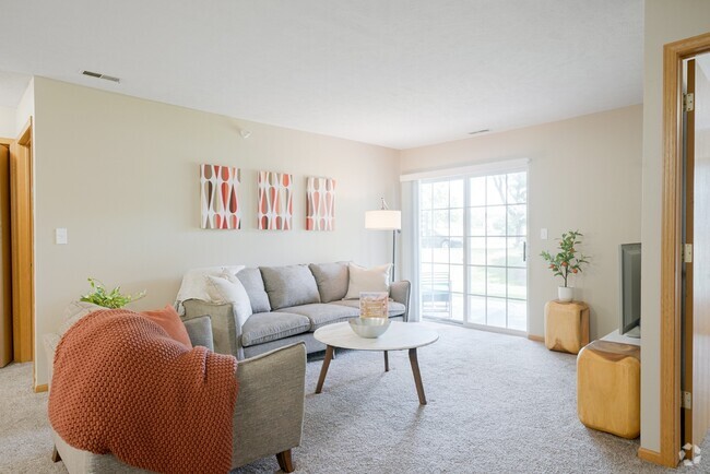 Our bright and cozy living rooms feature large sliding doors, inviting natural light and seamless indoor-outdoor living. - Williamsburg Park Apartments