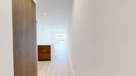 Located at 1339 Tamarind Ave in the heart of Hollywood, Los Angeles, this modern unit offers five bedrooms and four bathrooms across a single thoughtfully designed floor. Light-toned hardwood flooring runs throughout, creating a clean, cohesive aesthetic that complements the crisp white walls and recessed lighting found in every room.

The open-plan living area is spacious and bright, with large windows inviting generous natural light and views of the surrounding neighborhood. It flows seamlessly into a well-appointed kitchen featuring rich walnut-toned cabinetry, white quartz countertops, and a full suite of stainless steel appliances including a professional-grade range, built-in microwave, full-size refrigerator, and dishwasher.

The bedrooms are generously proportioned, with the primary bedroom offering mirrored sliding closet doors and a private sliding glass door leading to an outdoor balcony. Additional bedrooms feature large windows with neighborhood views, maintaining the unit's bright and airy character throughout.

The four bathrooms are finished in a modern style, each featuring wood-toned vanities with white countertops and large mirrors. Full bathrooms include glass-enclosed walk-in showers with tiled surrounds, while all bathrooms maintain the same clean, contemporary design language found throughout the unit.