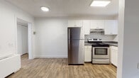 This single-floor unit offers a clean, practical layout designed for comfortable everyday living. The open kitchen is equipped with stainless steel appliances, including a full-size refrigerator and an electric range, complemented by white shaker-style cabinetry, granite-look countertops, and a range hood. Wood-look vinyl plank flooring runs throughout the kitchen and living areas, providing a warm, cohesive aesthetic that is easy to maintain.

The living area is generously proportioned, featuring white walls, a textured ceiling, and a window fitted with horizontal blinds that allows natural light to brighten the space. The layout flows efficiently between the kitchen and living zones, making the area feel open and connected.

The bedrooms are finished with neutral-toned carpet and feature windows with blinds, offering a quiet and comfortable setting. White walls and textured ceilings are consistent throughout, contributing to a uniform, well-maintained appearance.

The bathroom includes wood-look tile flooring, a white vanity with under-cabinet storage, a wall-mounted mirror, a soaking tub, and windows that bring in natural light. Overall, the unit presents a tidy, functional interior with consistent finishes throughout.