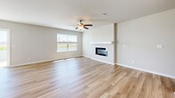 Located at 1424 NE 56th Ln in Ankeny, Iowa, this two-story home offers a well-designed layout across two floors, providing ample space for everyday living. The main floor features a bright, open-concept living room and kitchen area anchored by light hardwood flooring throughout. The living room is highlighted by a sleek fireplace with a clean white mantle and a ceiling fan, with a window allowing natural light to fill the space. The kitchen is equipped with white shaker-style cabinetry, stainless steel appliances, and a spacious island with quartz countertops — an ideal setup for cooking and entertaining. Upstairs, four carpeted bedrooms offer comfortable retreats, including a generously sized primary bedroom. The bathrooms are finished with light wood-look flooring, white vanities with quartz countertops, and clean, modern fixtures — one full bath features a double vanity and a tub-shower combo. A dedicated laundry room with a full-size washer and dryer adds everyday convenience. The attached garage provides secure parking and additional storage. Outside, the home features gray vinyl siding, a fenced backyard with green lawn space, and central air conditioning — completing this move-in-ready home.