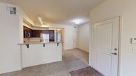 This single-floor, one-bedroom, one-bathroom unit offers a practical and comfortable layout designed for efficient living. The open-concept kitchen and living area serves as the heart of the space, where a peninsula counter with bar seating connects the two zones seamlessly. The kitchen is well-equipped with rich dark-stained cabinetry, light granite-style countertops, a full suite of stainless steel appliances including a gas range, built-in microwave, and refrigerator, as well as a stainless steel sink. Track lighting overhead provides ample illumination throughout the kitchen area, while wood-look flooring adds a clean, polished finish. The living area transitions to plush wall-to-wall carpet, creating a warm and comfortable atmosphere. The bedroom is a comfortably sized retreat featuring soft carpeting, a ceiling fan with light fixture, window with blinds for natural light and privacy, and a closet with a paneled door. The bathroom includes a soaking tub and shower combination with white tile surround and built-in shelving, complemented by wood-look flooring and a small window for ventilation. Neutral tones throughout the unit create a bright, cohesive ambiance well-suited to a variety of interior styles.