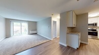 Located at 4751 St Joseph Creek Rd in Lisle, Illinois, this single-floor unit offers a thoughtfully designed layout with a clean, neutral aesthetic throughout. The open-concept living and dining area features a combination of wood-look hard flooring and plush carpeting, with soft gray walls and crisp white trim. A large sliding glass door floods the living space with natural light and provides outdoor views, while a ceiling fan adds both function and character to the room.

The kitchen is outfitted with white cabinetry, light stone-finish countertops, a subway tile backsplash, and stainless steel appliances including a range, over-the-range microwave, and sink — providing a modern, efficient cooking space.

The bedroom is carpeted for comfort and features a generous closet with double doors and a built-in shelving rod, offering ample storage. The adjacent hallway connects the living areas to the bathroom, which is finished with large-format gray tile surrounding a soaking tub and shower, complemented by a white vanity with brushed nickel hardware and a stone-finish countertop. The overall design is clean, consistent, and move-in ready.