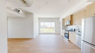 Located at 611 N Virgil Avenue in the heart of Los Angeles, this modern 3-bedroom, 3-bathroom residence offers a thoughtfully designed single-floor layout with contemporary finishes throughout. Light-toned hardwood flooring flows seamlessly across the open-concept living and kitchen area, creating a bright and cohesive aesthetic. Large picture windows flood the living space with abundant natural light while framing views of the surrounding Los Angeles cityscape and tree canopy.

The kitchen is outfitted with stainless steel appliances including a gas range, microwave, and refrigerator, complemented by light wood cabinetry and a white subway tile backsplash. The open layout connects the kitchen directly to the living area, making the space highly functional for everyday living.

Each of the three bedrooms features the same warm wood flooring and generously sized windows that invite natural light and offer elevated views of the neighborhood. The bedrooms provide comfortable, well-proportioned spaces with clean white walls and a minimalist feel.

All three bathrooms are finished with striking floor-to-ceiling green ceramic tile in the walk-in showers, paired with terrazzo-style flooring and natural wood vanities accented by matte black hardware. Glass shower enclosures complete the polished, modern look. A connecting hallway ties all rooms together efficiently, enhancing the overall flow of this well-appointed Los Angeles residence.