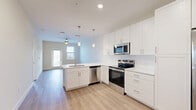 Located at 1023 Gull Ln in Melbourne, FL, this well-designed single-floor residence offers a thoughtfully planned layout across a comfortable footprint. The open-concept living, dining, and kitchen area serves as the heart of the home, anchored by a sleek kitchen featuring white shaker cabinetry, quartz countertops, stainless steel appliances — including a French door refrigerator, electric range, built-in microwave, and dishwasher — and a peninsula with pendant lighting overhead. Light wood-tone flooring flows throughout the main living areas, enhancing the bright, airy atmosphere created by neutral walls and recessed lighting. The living area is equipped with a ceiling fan and connects to a private balcony with outdoor views, accessible through a glass-paneled door. The spacious bedroom is finished with plush carpet, a ceiling fan, and double windows that invite natural light. Two closets provide generous storage, and direct access leads to the full bathroom, which showcases a glass-enclosed walk-in shower with large-format tile, a white vanity with undermount sink, and wood-look flooring. A dedicated laundry area completes this clean, modern residence.
