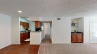 This single-floor residence in Ashley Park, Richmond, VA offers a practical and well-organized layout throughout. The kitchen is equipped with warm wood cabinetry, granite-style countertops, black appliances including a refrigerator and dishwasher, and durable hardwood-style flooring. A peninsula with additional counter space connects the kitchen to the adjoining living and dining areas, which feature neutral carpet and a built-in cabinet nook with open shelving — a distinctive architectural detail adding both storage and character.

The living area is bright and open, benefiting from natural light through window treatments and access to an exterior door. Multiple bedrooms are carpeted and generously sized, each with windows that allow natural light and views of the surrounding neighborhood. One entry area features hardwood-style flooring, providing a practical transition space.

Two bathrooms serve the unit, each featuring granite-style countertops, single-basin sinks with wood vanity cabinetry, and shower/tub combinations. Textured ceilings are consistent throughout the home. The overall layout, visible in the 3D overview, reflects a compact yet functional design well-suited for comfortable everyday living.