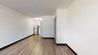 Located at 3030 W Sam Houston Pkwy S in Houston, Texas, this single-floor unit offers a clean, modern aesthetic with thoughtfully updated finishes throughout. The open living area features warm wood-look vinyl plank flooring and crisp white walls, creating a bright and welcoming atmosphere. A textured ceiling adds subtle character to the space, while dark baseboards provide a sharp contrast that frames each room.

The kitchenette is efficiently designed and well-equipped, featuring white shaker-style cabinetry, a decorative mosaic tile backsplash in shades of gray and white, a stainless steel refrigerator, a built-in microwave, and a single-basin sink. A stylish gold-toned chandelier overhead adds a touch of contemporary flair. An adjacent open shelving unit offers convenient additional storage.

The bathroom showcases a refined marble-look quartz countertop with an undermount sink and chrome fixtures. A tub-shower combination with a curtain rod completes the space, all finished in a clean white palette that enhances the sense of brightness.

The remaining living areas are open and versatile, offering ample room for flexible furniture arrangements. Consistent flooring and neutral white walls flow seamlessly throughout, lending the unit a cohesive and move-in-ready feel.