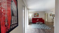 This single-floor residence offers a well-organized layout with distinct living, dining, kitchen, and sleeping areas connected by consistent wood-look flooring and neutral warm-toned walls throughout.

The living room serves as the heart of the home, featuring a textured ceiling, vertical blinds along a sliding door that allows natural light to pour in, and an open sightline to a compact wet bar area complete with a countertop, bar stool, and decorative mirror — ideal for entertaining.

The galley-style kitchen is efficiently designed with dark cabinetry lining both sides, granite-look countertops, a stainless steel sink, electric range, and a refrigerator. Track lighting overhead illuminates the full length of the kitchen, enhancing its functionality.

Two bedrooms offer comfortable retreats, each carpeted and equipped with ceiling fans with light fixtures and windows fitted with blinds for natural light and privacy. Both rooms provide ample space for furnishings.

The bathrooms are finished with granite-look vanity countertops and dark cabinetry. One bathroom features a full tub-shower combination with tiled surround, while the second serves as a more compact yet equally well-appointed space. Both share the same cohesive design aesthetic found throughout the home.