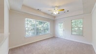 Located at 50 Greenleaf Road in Conyers, GA, this 1-bedroom, 1-bathroom unit offers a thoughtfully arranged single-floor layout that maximizes comfort and functionality. The open-concept kitchen and living area forms the heart of the home, with the kitchen showcasing white cabinetry with modern hardware, quartz-style countertops, a subway tile backsplash, and black appliances including a range and dishwasher. Light wood-look flooring and a window overlooking lush greenery give the kitchen a clean, bright feel. The living area flows naturally from the kitchen and features plush carpeting and generous natural light. The spacious primary bedroom is carpeted and includes a tray ceiling with crown molding detailing, a ceiling fan, and a large window framing tranquil views of surrounding trees. A dedicated closet provides ample storage, and an in-unit washer is visible nearby, adding everyday convenience. The bathroom is finished with light wood-look tile flooring, a white vanity with under-sink storage, and a clean, neutral palette. Throughout the unit, soft neutral tones, white trim, and an abundance of natural light create a cohesive, welcoming ambiance.