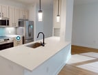 This contemporary apartment, located in Upper Kirby #309, offers a generous 1370 square feet of living space on a single floor. The open-concept design seamlessly integrates the kitchen and living areas, creating a spacious and airy atmosphere. The kitchen boasts sleek, light-colored cabinetry, stainless steel appliances, and a stylish backsplash, perfect for culinary enthusiasts.

The apartment features two bedrooms, including a primary bedroom measuring 210 square feet, providing ample space for relaxation. Both bathrooms are modern and well-appointed, with one showcasing elegant marble-like tiling in the shower area. The unit includes a dedicated laundry room with full-sized washer and dryer, enhancing convenience for residents.

Large windows throughout the apartment flood the rooms with natural light, while ceiling fans ensure comfortable air circulation. The bedrooms and living areas are adorned with warm, wood-toned flooring, adding a touch of elegance to the space. Multiple closets, including three separate storage areas, offer abundant storage options.

The apartment's neutral color palette and clean lines create a contemporary aesthetic, allowing for versatile decorating possibilities. A sliding glass door in one of the rooms provides access to an outdoor space, likely a balcony, extending the living area and offering a connection to the outdoors. This thoughtfully designed apartment combines modern amenities with practical living spaces, making it an ideal urban dwelling.