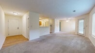 Located in Sharonville, Ohio, this one-bedroom, one-bathroom home offers a well-organized single-level layout with a thoughtful mix of flooring and functional living spaces. The open-concept living and kitchen area serves as the heart of the home, where soft carpet in the living room transitions to warm hardwood-style flooring in the kitchen. A half-wall partition neatly defines the two spaces while maintaining an open, connected feel. The galley-style kitchen is efficiently laid out with warm wood cabinetry, white appliances including a dishwasher, electric range, microwave, and refrigerator, all set atop hardwood-style floors with ample counter and storage space. The spacious bedroom is carpeted and receives natural light through a large window with outdoor views of surrounding greenery, creating a calm and comfortable atmosphere. A dedicated walk-in closet off the bedroom features built-in wire shelving units on multiple walls, providing generous and organized storage. The full bathroom is finished in a clean, all-white palette with a tiled tub-and-shower combination, hardwood-style flooring, and classic chrome fixtures. A textured ceiling throughout the main living areas adds a traditional touch, while ceiling fans contribute to overall comfort and airflow.