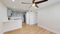 Located at 6319 25th St S in Saint Petersburg, FL, this thoughtfully designed one-bedroom, one-bathroom home maximizes its single-floor layout with a clean, modern aesthetic throughout. Light-toned luxury vinyl plank flooring flows continuously across the living spaces, complemented by crisp white walls and recessed lighting that keep the interior bright and airy.

The open-concept kitchen and living area serves as the heart of the home. The kitchen is outfitted with gray shaker-style cabinetry, white quartz countertops, a peninsula island for additional prep space or casual dining, and a full suite of stainless steel appliances including a refrigerator, range, microwave, and dishwasher. A ceiling fan with integrated lighting anchors the living area.

The bedroom is a comfortable retreat, featuring a ceiling fan, natural light from windows with views of the surrounding greenery, and direct access to a dedicated closet with built-in shelving. The bathroom showcases full white subway tile surrounds a soaking tub and tub-filler with matte black fixtures, adding a sleek, contemporary contrast. A dedicated laundry area with a stacked washer and dryer rounds out the unit's practical amenities, making this home a well-appointed and functional living space.