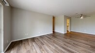 Located at 3550 Woodbridge Dr in Evansville, Indiana, this generously sized single-floor home offers three bedrooms, two bathrooms, and an expansive, well-connected layout. The interior is unified by durable wood-look flooring that flows seamlessly from room to room, complemented by neutral warm-gray walls and clean white trim throughout.

The open-concept kitchen and living area serves as the heart of the home. The kitchen features white shaker-style cabinetry, gray stone-look countertops, and stainless steel appliances, including an electric range with microwave. The adjacent living space is bright and airy, highlighted by a ceiling fan and a sliding glass door that fills the room with natural light and opens to views of lush greenery beyond.

Each of the three bedrooms is well-proportioned, with the spacious primary bedroom offering ample room for furnishings. The bedrooms feature large windows with blinds that invite natural light and overlook the surrounding tree-lined landscape. Two dedicated closets add practical storage throughout.

The two bathrooms are finished consistently with the rest of the home, each featuring a tub-shower combination, toilet, and vanity with matching gray countertops and brushed nickel hardware. A private outdoor balcony rounds out the home, offering peaceful views of open green space.