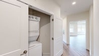 This single-floor residence on Tamarack Circle in Skillman, NJ offers a thoughtfully designed layout across two bedrooms and two bathrooms. The open-concept kitchen and living area serves as the heart of the home, featuring warm wood-tone flooring, recessed lighting, and an abundance of natural light from multiple windows. The kitchen is appointed with dark cabinetry, stainless steel appliances including a gas range, microwave, and refrigerator, complemented by light granite countertops and a central island ideal for dining or prep work.

The spacious primary bedroom features wood-style flooring, a large window overlooking lush greenery, and generous proportions. The second bedroom is finished with plush carpeting and a wide window that frames outdoor views. Both bathrooms are finished consistently with dark vanity cabinetry, white countertops, large mirrors with chrome lighting fixtures, and neutral tile flooring. One bathroom includes a shower-tub combination.

Two hallways connect the living spaces efficiently, and a dedicated laundry closet with a stacked washer and dryer adds everyday convenience. The overall aesthetic is clean, modern, and move-in ready.