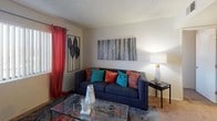 This single-floor residence at 6231 W McDowell Rd in Phoenix, Arizona, offers a practical and comfortable layout designed for everyday living. The living room serves as the heart of the home, featuring neutral walls, textured ceilings, and windows dressed with bold drapes that allow natural light to filter in. The space is warm and welcoming, with room for a full seating arrangement and decorative accents that add personality. The kitchen is efficiently designed with light wood cabinetry, black appliances including a refrigerator, electric range, and dishwasher, along with wood-look flooring and recessed lighting overhead. A dedicated space for in-unit laundry adds everyday convenience. The bedrooms are carpeted and well-proportioned, each offering closet storage — one with a sliding-door closet and another with an open reach-in closet — along with windows that bring in natural light and views of the surrounding neighborhood. The bathroom is clean and functional, featuring a single vanity with a wide mirror, a shower-tub combination, and wood-look flooring that ties the space together. Throughout the residence, the consistent neutral palette and practical finishes create a cohesive, move-in-ready atmosphere suited for comfortable Phoenix living.