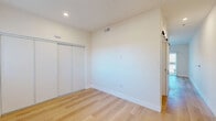 Located at 2301 Ulric Street in San Diego, CA, this thoughtfully designed studio offers a clean, modern aesthetic throughout its single-floor layout. Light oak-toned hardwood flooring runs continuously across all areas, lending warmth and visual cohesion to the space.

The open-plan living, dining, and kitchen area forms the heart of the unit. The kitchen is outfitted with white shaker-style cabinetry, a subway tile backsplash, and a full suite of stainless steel appliances including a gas range, refrigerator, dishwasher, and over-the-range microwave. Recessed lighting illuminates the space efficiently. The living area flows naturally toward a sliding glass door that opens onto a private balcony, allowing natural light to pour in and providing outdoor views of the surrounding neighborhood.

The bedroom area is a well-proportioned, bright room featuring a sliding-door closet and a barn-style door, maintaining the modern design language of the unit. The full bathroom is finished in crisp white, featuring a walk-in shower/tub combination with matte black fixtures, a white vanity with storage drawers, a lighted mirror, and built-in open shelving for additional storage. Consistent hardwood-style flooring extends into the bathroom, reinforcing the unit's unified design. Recessed lighting and HVAC vents are present throughout, ensuring comfort and functionality.