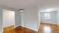 Located at 6079 Bellview Dr in Falls Church, VA, this three-bedroom, one-bathroom unit offers a well-organized single-floor layout designed for comfortable everyday living. Warm parquet hardwood flooring flows consistently throughout the living areas and all three bedrooms, adding a timeless, classic character to the space. The open entry area provides a welcoming first impression, leading naturally into the rest of the home. The generously sized primary bedroom is a standout feature, offering ample room to customize, and includes a large triple-panel closet and a wall-mounted mini-split unit for individualized climate control. Two additional bedrooms each benefit from natural light streaming through sizable windows that frame views of surrounding greenery, creating a bright and airy feel. The kitchen is outfitted with white cabinetry, granite-style countertops, a stainless steel sink, and marble-look tile flooring, giving it a clean, updated aesthetic. The bathroom is elegantly appointed with large-format marble-style wall tiles surrounding a full soaking tub and shower combination, complemented by a window that brings in natural light. A connecting hallway ties all rooms together efficiently, making this a practical and inviting home.