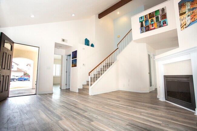 Living room w/main entrance, stairs, bathroom entrance, and entrance to downstairs bedroom - 26031 Clifden Ct