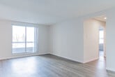 Located at 315 Margaret Ave in Kitchener, Ontario, this well-organized 2-bedroom, 2-bathroom residence offers a practical and comfortable layout across a single floor. The interior features a neutral colour palette with light-toned walls and laminate hardwood flooring throughout the main living areas, creating a clean and cohesive feel.

The kitchen is accessed through an archway and is fitted with white cabinetry, a dark stone-style countertop, a double sink, and white appliances, including a range and refrigerator. Tile flooring in the kitchen adds a practical touch. The two living areas provide flexible space for both lounging and dining.

The primary bedroom is generously sized, featuring a large sliding glass door that floods the room with natural light and offers views of the surrounding neighbourhood. The second bedroom also benefits from natural light through a dedicated window. Both bedrooms are served by dedicated closets with built-in shelving rods for organized storage.

The two bathrooms are finished with tile flooring, stone-style countertops, and white vanity cabinetry. One bathroom includes a full soaker tub and shower combo with a grab bar. Two hallways connect the rooms efficiently, and a ceiling fan in one of the living areas adds comfort. The unit presents a bright, move-in-ready living environment.