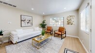 Located at 10032 N Magnolia Ave in Santee, California, this two-story, 2-bedroom, 2-bathroom home offers a thoughtfully designed layout spread across two well-proportioned floors. The main level welcomes you into a bright and airy living room featuring recessed lighting, light wood-style flooring, and large windows that invite abundant natural light. The updated kitchen is a standout feature, showcasing crisp white shaker cabinetry, stone-look countertops, a double-basin sink, and a full suite of stainless steel appliances including a refrigerator, dishwasher, range, and over-the-range microwave. Light wood flooring continues throughout the kitchen, enhancing its clean, modern aesthetic. The two bathrooms are finished with stone-look countertops and white cabinetry; one includes a tub/shower combination with tile flooring, while the other features wood-style flooring and a large mirror. Both bedrooms are located on the upper level, each offering plush carpet, ceiling fans, and a comfortable, restful atmosphere. The spacious primary bedroom benefits from a large window with views of surrounding greenery. Two closets provide convenient storage throughout the home. With a neutral color palette and modern finishes, this home offers a clean and inviting living environment in a well-established Santee neighborhood.