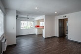 Located at 161 E 18th St in Costa Mesa, California, this single-story residence offers a clean, updated interior with a bright and functional layout. The open living area features warm luxury vinyl plank flooring, recessed lighting, and white walls that create a fresh, airy atmosphere. Natural light flows in through multiple windows fitted with blinds, and a wall-mounted air conditioning unit ensures year-round comfort. A sliding glass door leads to a private outdoor patio, accompanied by a ceiling fan overhead.

The galley-style kitchen is well-appointed with white cabinetry, light countertops, a bold orange accent backsplash, and stainless steel appliances including a gas range, microwave, and dishwasher. A double-basin sink sits beneath a window, adding natural light to the cooking space.

The bedroom features plush carpeting, mirrored sliding closet doors that enhance the sense of space, and a window with blinds. A second carpeted room provides additional flexible living space. The bathroom is cleanly finished with a single-sink vanity, a mirrored medicine cabinet, and a full tub-shower combination. Throughout, the residence maintains a cohesive, move-in-ready aesthetic suited to comfortable everyday living in Orange County.