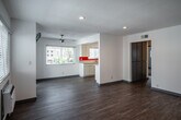 Located at 161 E 18th St in Costa Mesa, California, this single-story residence offers a clean, updated interior with a bright and functional layout. The open living area features warm luxury vinyl plank flooring, recessed lighting, and white walls that create a fresh, airy atmosphere. Natural light flows in through multiple windows fitted with blinds, and a wall-mounted air conditioning unit ensures year-round comfort. A sliding glass door leads to a private outdoor patio, accompanied by a ceiling fan overhead.

The galley-style kitchen is well-appointed with white cabinetry, light countertops, a bold orange accent backsplash, and stainless steel appliances including a gas range, microwave, and dishwasher. A double-basin sink sits beneath a window, adding natural light to the cooking space.

The bedroom features plush carpeting, mirrored sliding closet doors that enhance the sense of space, and a window with blinds. A second carpeted room provides additional flexible living space. The bathroom is cleanly finished with a single-sink vanity, a mirrored medicine cabinet, and a full tub-shower combination. Throughout, the residence maintains a cohesive, move-in-ready aesthetic suited to comfortable everyday living in Orange County.