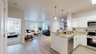 Located at 500 N Broadway in Farmington, Utah, this single-story, 2-bedroom, 2-bathroom residence offers a thoughtfully designed open-concept layout with clean, contemporary finishes throughout. The combined kitchen and living area serves as the heart of the home, where light wood-tone flooring flows seamlessly underfoot. The kitchen is outfitted with crisp white shaker cabinetry, granite countertops, stainless steel appliances including a gas range and built-in microwave, and a peninsula with pendant lighting — ideal for both cooking and casual dining. The living room receives ample natural light through large windows and features a ceiling fan overhead, creating a bright and comfortable gathering space. Both bedrooms are carpeted for warmth and comfort, with the primary bedroom offering a walk-in closet and an en suite bathroom complete with a soaking tub, white vanity cabinetry, and granite countertops. The second bathroom mirrors the same refined style with a tub/shower combination and matching finishes. In-unit laundry adds everyday convenience, while five closets throughout provide generous storage. A private patio extends the living space outdoors, rounding out this well-equipped and efficiently designed residence.