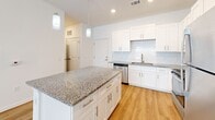 Located at 597 Wildlight Avenue in Yulee, Florida, this one-bedroom, one-bathroom residence offers a well-designed, single-story layout with a clean, modern aesthetic throughout. Light wood-style flooring runs continuously across all living areas, complementing the bright white walls and creating a cohesive, airy feel.

The open-concept kitchen and living area serves as the heart of the home. The kitchen is equipped with crisp white shaker-style cabinetry, a classic subway tile backsplash, granite countertops, and a full suite of stainless steel appliances including a refrigerator, range, microwave, and dishwasher. A central island with matching granite provides additional prep space and pendant lighting overhead adds a polished touch. The adjacent living area is generously proportioned, featuring a ceiling fan and a large window that invites natural light.

The bedroom is a comfortable, well-lit retreat with its own ceiling fan, a window with blinds, and access to a dedicated closet. The bathroom continues the home's refined finish with granite-topped white cabinetry, a tub/shower combination, and wood-style flooring. Clean lines and consistent finishes give the entire residence a fresh, move-in-ready appeal.