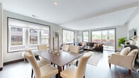 Located at 253 Lake St E in Wayzata, MN, this thoughtfully designed single-floor residence offers three bedrooms and four bathrooms with a clean, modern aesthetic. The open-concept living, dining, and kitchen area serves as the heart of the home, bathed in natural light from large windows and sliding glass doors that frame outdoor views. The living room features a generous layout with neutral tones, while the dining area comfortably accommodates a full-sized table for entertaining. The chef's kitchen is outfitted with dark wood cabinetry, a large central island with a quartz countertop, marble-tiled backsplash, stainless steel appliances, and rich hardwood flooring. A sleek hallway with dark-framed doors and hardwood floors connects the main living area to the private quarters. The spacious primary bedroom includes sliding glass door access to an outdoor space and is complemented by a well-appointed en-suite bathroom featuring herringbone tile flooring, a glass-enclosed walk-in shower, and dark vanity cabinetry. Additional bedrooms are carpeted and bright, each with easy access to their own bathrooms. A dedicated utility room houses an in-unit washer and dryer. The walk-in closet offers built-in shelving and mirrored sliding doors, maximizing storage and functionality throughout.