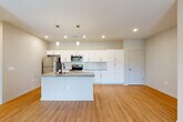 Located at 17801 Cypress Dr. in Omaha, Nebraska, this well-appointed two-bedroom, two-bathroom residence offers a thoughtfully designed single-level layout with a clean, modern aesthetic throughout. The open-concept kitchen and living area serves as the heart of the home, anchored by a central island with a granite countertop and integrated sink, complemented by pendant lighting overhead. The kitchen features crisp white shaker-style cabinetry, a subway tile backsplash, stainless steel appliances, and recessed lighting, all flowing seamlessly into a spacious living area with warm luxury vinyl plank flooring. Natural light enters through a window and glass door in the living space, enhancing the bright, neutral color palette. The generously sized primary bedroom offers plush carpeting and access to a walk-in closet equipped with wire shelving systems for ample storage. The primary bathroom includes a walk-in shower, white vanity cabinetry with granite countertops, and matte black fixtures. The second bedroom is carpeted and well-proportioned, while the second bathroom features a full tub-shower combo with matte black hardware. Consistent luxury vinyl plank flooring runs through the main living areas, tying the space together with a cohesive, contemporary feel.