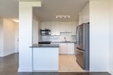 Located at 4979 Bathurst St in Toronto's North York neighbourhood, this well-appointed 2-bedroom, 1-bathroom unit offers a thoughtfully designed layout across a single floor. The open-concept kitchen flows seamlessly into the living room, creating a bright and functional common area. The kitchen is outfitted with white shaker-style cabinetry, a subway tile backsplash, stainless steel appliances including a full-size refrigerator, dishwasher, and microwave, as well as a central island with a dark countertop that provides additional prep and storage space. Light tile flooring runs throughout the kitchen, transitioning to classic parquet hardwood in the living and bedroom areas. Large windows in the living room invite an abundance of natural light and offer open views of the surrounding neighbourhood. Both bedrooms are comfortably sized, each featuring parquet flooring, individual windows with outdoor views, and radiator heating. The primary bedroom includes a mirrored sliding-door closet. The bathroom is finished with white subway tile surrounding a soaker tub and shower combo with chrome fixtures. The overall aesthetic is clean, bright, and move-in ready.