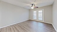 This 530 square foot apartment, located at 1841 Lascassas Pike in Murfreesboro, Tennessee, offers a well-designed living space on a single floor. The layout includes a spacious living room, one bedroom measuring 150 square feet, a full bathroom, and a hallway with a closet for added storage.

The apartment features a mix of flooring types, with durable wood-look laminate in the main living areas and plush carpeting in the bedroom. The neutral color palette, dominated by light gray walls and white trim, creates a bright and airy atmosphere throughout the space.

The living room is highlighted by a ceiling fan with integrated lighting and French doors that lead to an outdoor area, allowing natural light to flood the space. The bedroom, while compact, includes a window for additional natural light and ventilation.

The bathroom, though not expansive, is efficiently designed with a combination tub and shower, featuring a white shower curtain for privacy. The overall design of the apartment emphasizes functionality and modern aesthetics, making excellent use of the available square footage to create a comfortable living environment.