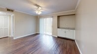 Located at 3415 W Hillsborough Ave in Tampa, FL, this one-bedroom, one-bathroom unit offers a well-organized single-floor layout designed for comfortable everyday living. The combined kitchen and living area serves as the heart of the home, where rich hardwood-style flooring, crown molding, and a ceiling fan create a warm, polished atmosphere. A full-width sliding glass door floods the living space with natural light and opens to a view of lush greenery, offering a refreshing connection to the outdoors. A built-in cabinet with granite countertop adds a functional and stylish accent to the living area. The kitchen features white cabinetry, granite countertops, a peninsula with a sink, and a full suite of stainless steel appliances, including a refrigerator, microwave, and range. The bedroom is carpeted for comfort, includes a ceiling fan, and benefits from a natural light-filled window. A spacious walk-in closet with multi-level wire shelving provides generous storage. The bathroom is finished with a granite-topped vanity, white cabinetry, hardwood-style flooring, and a full tub-shower combination. Textured ceilings are found throughout, completing the unit's cohesive design.