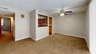 Located at 4285 Chestnut Ridge Rd in Buffalo, NY, this two-bedroom, two-bathroom residence offers a practical and well-organized single-floor layout. The living room is a comfortable, carpeted space featuring a ceiling fan and a large window dressed with vertical blinds that invite natural light. A distinctive decorative spindle partition separates the living area from the kitchen, adding a touch of character. The kitchen is equipped with warm wood-toned cabinetry, a built-in dishwasher, a refrigerator, and overhead panel lighting, all set atop rich hardwood-style flooring. Both bedrooms are carpeted and well-lit, with windows fitted with vertical blinds. The primary bedroom is generously sized and features dual sliding-door closets, providing ample storage. The second bedroom also includes a sliding-door closet. Each bathroom is finished with hardwood-style flooring, a vanity with white cabinetry, and a tub-shower combination. Textured ceilings are consistent throughout the residence. Two hallways connect the living areas to the private quarters, and the entryway is accessible via a solid wood door, completing this efficiently designed home.