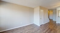 Located at 725 Mill Stream Ln in Lynchburg, Virginia, this two-story home offers five bedrooms, one bathroom, and a functional layout spread across two floors. The main level features a welcoming living room finished with durable dark hardwood-style flooring, neutral-toned walls, and a textured ceiling. Natural light filters in through a front-facing window alongside the entry door, which offers views of an outdoor deck area. A baseboard heating unit ensures comfortable warmth throughout the space. The main floor also includes an additional room with matching hardwood-style flooring, suitable for flexible use. Upstairs, the five carpeted bedrooms are finished in soft neutral tones, each providing a calm and comfortable atmosphere. Several bedrooms feature windows with blinds that invite natural light, while select rooms include built-in closets for convenient storage. The hallways connect the rooms efficiently across both levels. The shared full bathroom is clean and straightforward, equipped with a tub-shower combination and tile-style flooring. Throughout the home, clean white trim, consistent neutral paint, and low-maintenance finishes create a cohesive, move-in-ready aesthetic well-suited for a variety of occupancy needs.