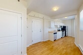 Located at 1538 Centre St in Detroit, MI, this 2-bedroom, 1-bathroom unit is thoughtfully laid out across a single floor. The interior opens into a combined kitchen and dining area, where white shaker-style cabinetry lines the walls alongside a full suite of stainless steel appliances, including a refrigerator, electric range, microwave, and dishwasher. A light-toned laminate countertop and integrated sink complete the kitchen. Warm hardwood-style flooring flows throughout the main living areas, complementing the bright, neutral wall tones. The dining area transitions into a cozy living room, accented by a curved bay window arrangement that draws in natural light and offers views of the surrounding neighborhood. Baseboard heating is present throughout the unit. The spacious primary bedroom features multiple windows, a wall-mounted AC unit, and continues the hardwood flooring, while the second bedroom is finished with plush carpeting for added comfort. Both bedrooms offer access to natural light. The shared full bathroom is finished in clean white tile, featuring a tub-shower combination and a pedestal-style sink. A hallway and utility room round out the practical layout of this well-organized Detroit residence.